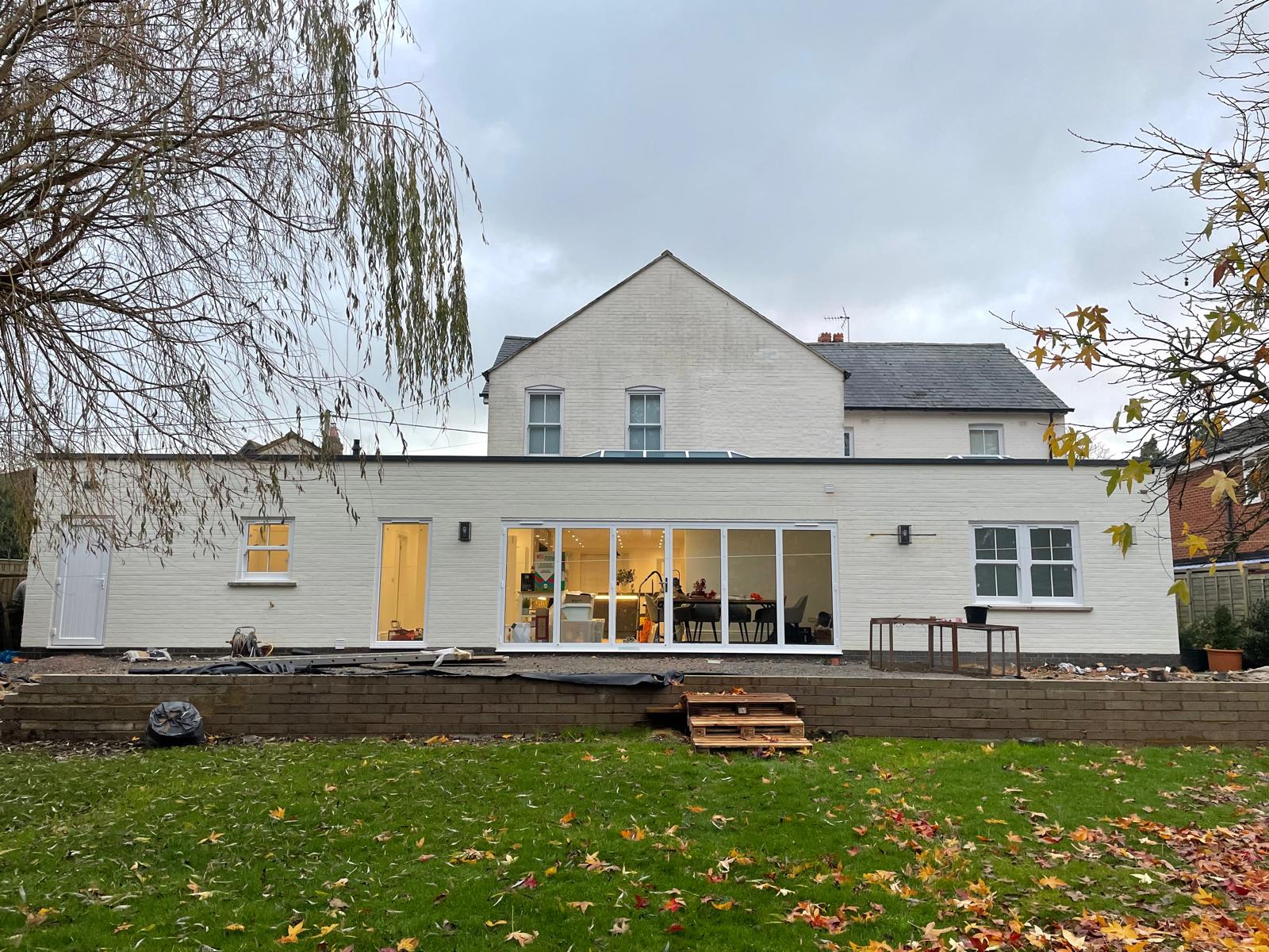 Finished single-storey white rendered rear extension with bi-fold doors by DBD Builders Ltd