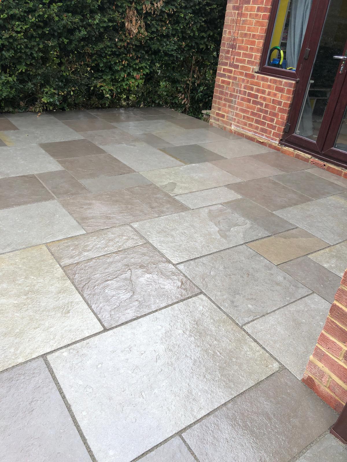 Riven sandstone patio laid outside French doors on a red brick house by DBD Builders Ltd