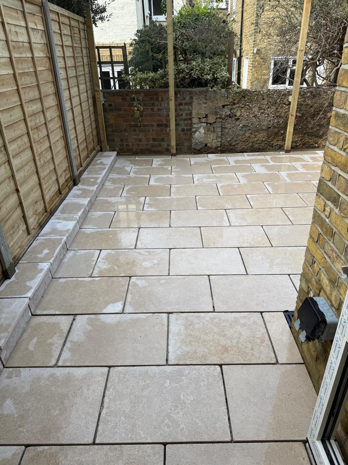 Travertine paved courtyard with stone step and new fencing by DBD Builders Ltd