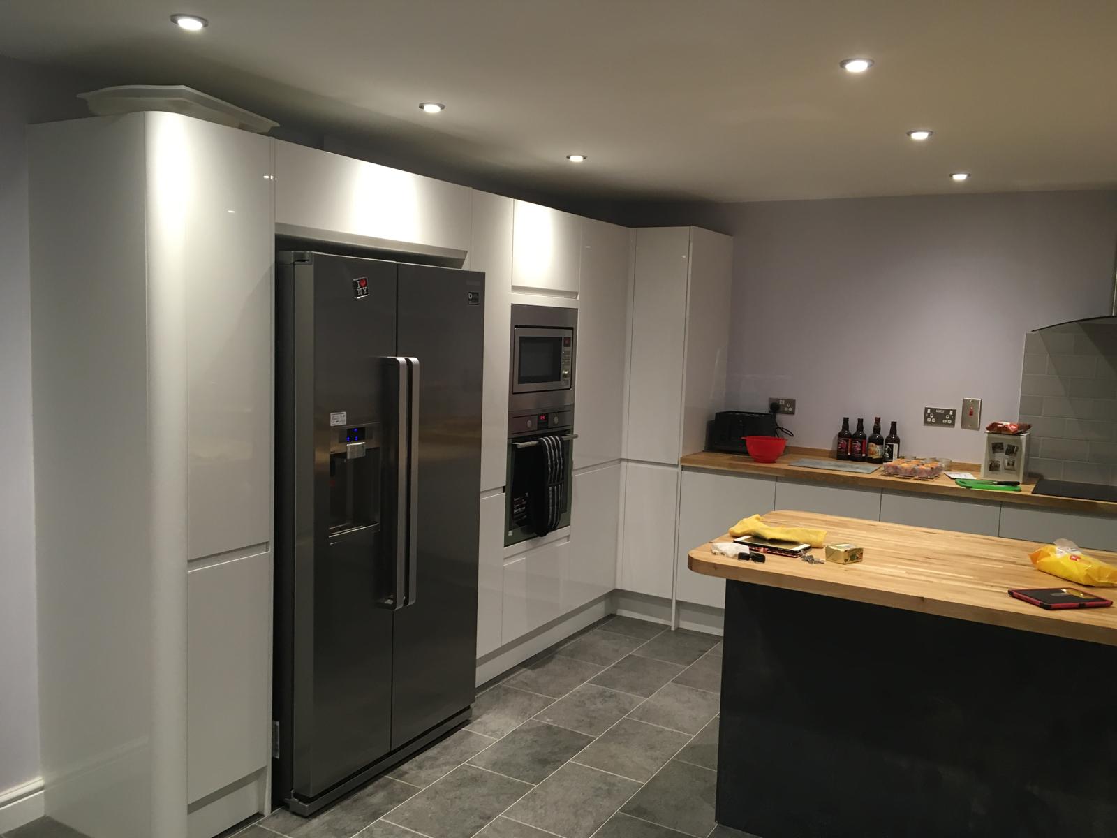 Gloss white handleless kitchen with oak worktops and integrated appliances fitted by DBD Builders Ltd